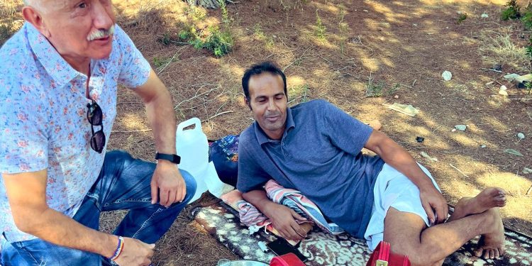 El secretario general de UGT habla con un trabajador que descansa a la intemperie en un asentamiento en Sant Josep donde viven otros trabajadores sin opción a una vivienda digna en Ibiza.