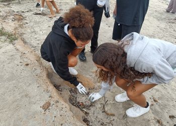 Dues de les estudiants recullen burilles i altres residus. Fotos: Noudiari