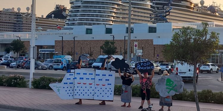 Los activistas junto a los tres cruceros, en el atardecer de ayer.