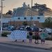 Los activistas junto a los tres cruceros, en el atardecer de ayer.