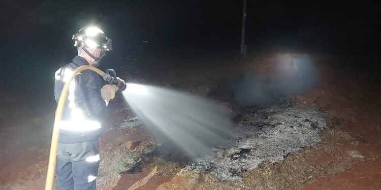 Un bombero apaga una quema de rastrojos mal apagada que amenazaba incendio anoche en Sant Joan. Fotos Bomberos