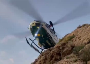 El helicóptero sobrevuela el acantilado para tratar de localizar el cuerpo desde el aire.