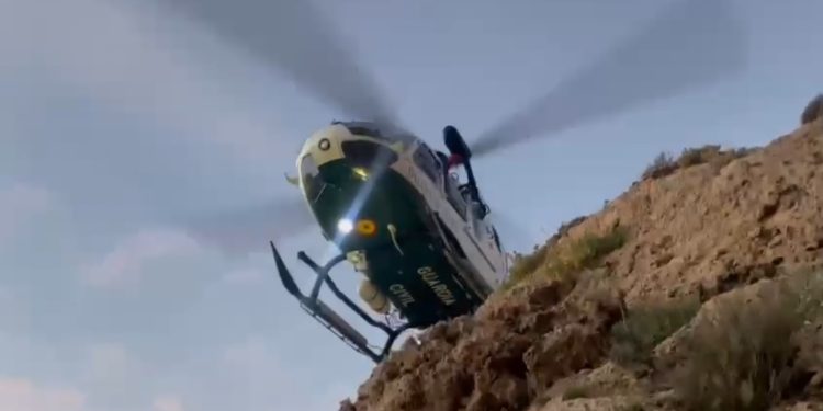 El helicóptero sobrevuela el acantilado para tratar de localizar el cuerpo desde el aire.