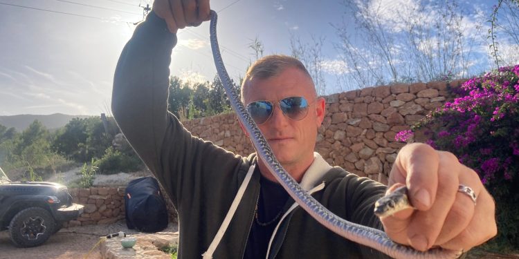 El voluntario Dean Gallagher con una serpiente capturada el año pasado en la Cala de Sant Vicent