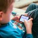 Un niño juega con un dispositivo móvil.