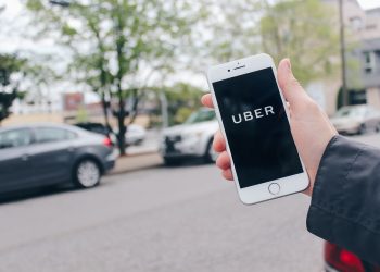 Una persona usando la aplicación de Uber.  www.quotecatalog.com