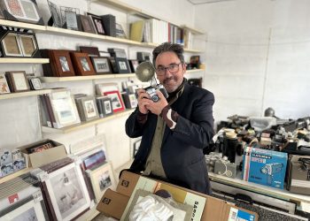 Rafa Domínguez, con una de las cámaras que usaba su padre para retratar bodas, rodeado de cámaras y material que estos días empaqueta de cara al cierre de Raymar. Foto L. F. A.