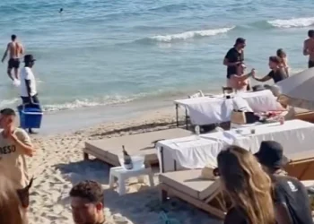 Mesas a escasos centímetros de la orilla, en una imagen de redes sociales enviada a este medio en la que también aparecen varios vendedores ambulantes en ses Salines en una imagen de julio del año pasado.