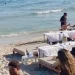 Mesas a escasos centímetros de la orilla, en una imagen de redes sociales enviada a este medio en la que también aparecen varios vendedores ambulantes en ses Salines en una imagen de julio del año pasado.