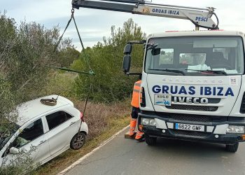 Un equipo de Grúas Ibiza retira el vehículo accidentado.