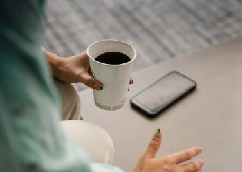 Una persona con un café de máquina. Pexels