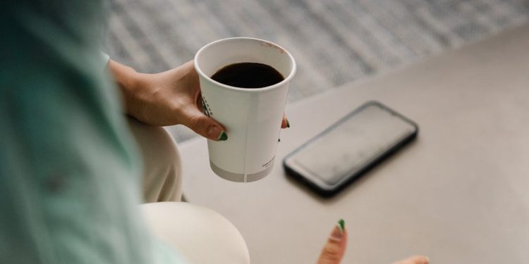 Una persona con un café de máquina. Pexels