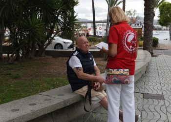 Una voluntaria informa a un ciudadano. Foto: IFCC
