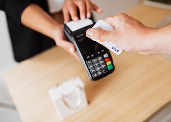 Una persona paga con una tarjeta VISA de crédito.