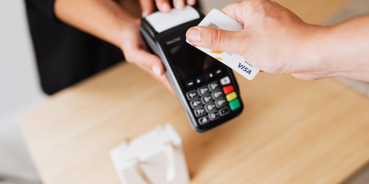 Una persona paga con una tarjeta VISA de crédito.