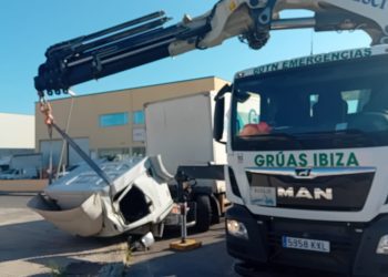 Un momento de la laboriosa maniobra para enderezar la cabina con una grúa de Grúas ibiza.