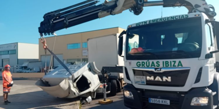 Un momento de la laboriosa maniobra para enderezar la cabina con una grúa de Grúas ibiza.