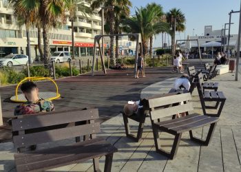 Tres personas dormitan en los bancos junto a un parque infantil de Ibiza, junto a la Estación Marítima de Formentera.