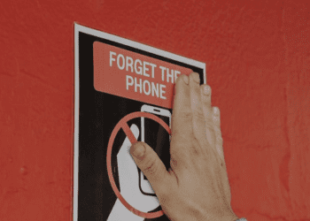 Colocando uno de los carteles que indicaban que no era posible usar móviles. Michael Bibi