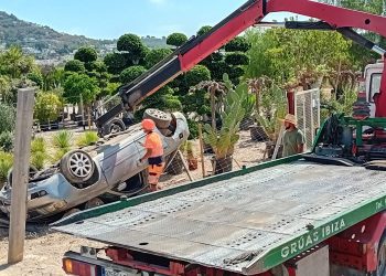 Operarios de Grúas Ibiza enderezan el coche.