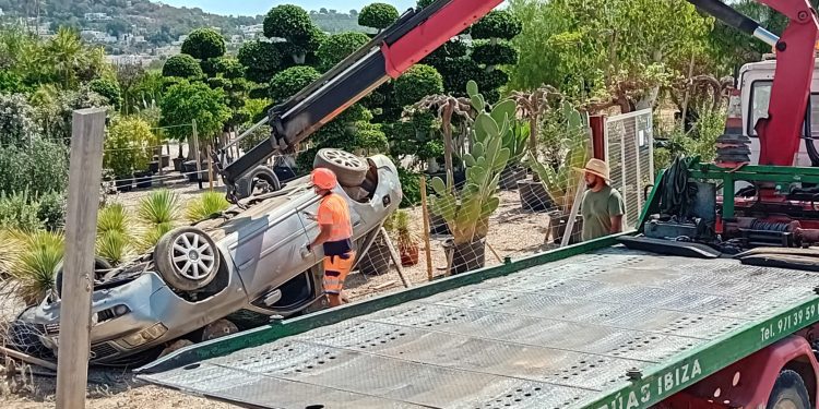 Operarios de Grúas Ibiza enderezan el coche.