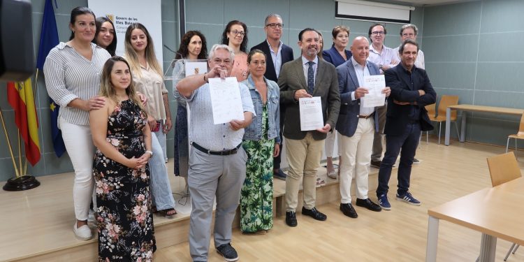Los asistentes a la reunión muestran el calendario acordado tras el encuentro.