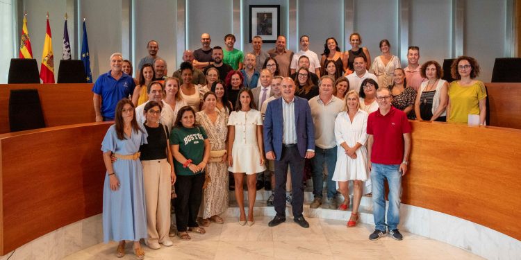 Vicent Marí y Maria Fajarnés rodeados del personal laboral y funcionarios que han tomado posesión de sus puestos.