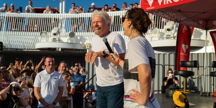 Richard Branson intenta hacer el paso de los canguros, junto a Raygun, que le mira a su derecha con el micrófono. FOTO: Virgin Voyages