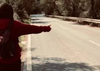 Un joven haciendo autostop en una carretera, en la imagen que han escogido para la campaña de recogida de firmas.