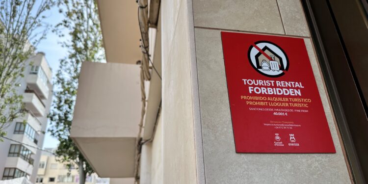 Un bloque de viviendas de la ciudad de Ibiza con un indicativo de que está prohibido el alquiler turístico. Foto L. F. A.