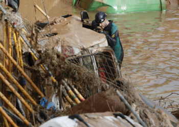 Expertos de la Guardia Civil buscan cuerpos sin vida entre los vehículos atrapados entre los cimientos de un edificio en construcción, este sábado, en Paiporta, Valencia. Foto: EFE/ Biel Aliño