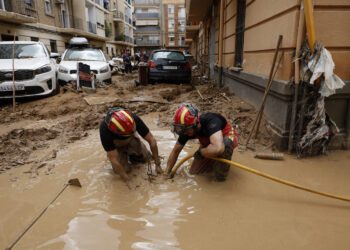 Efectivos de la UME limpian una calle afectada en Paiporta. EFE/Biel Aliño