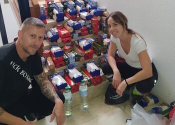 Héctor Hurtado con su pareja, recogiendo alimentos tras sobrevivir a la riada. Foto cedida a Noudiari