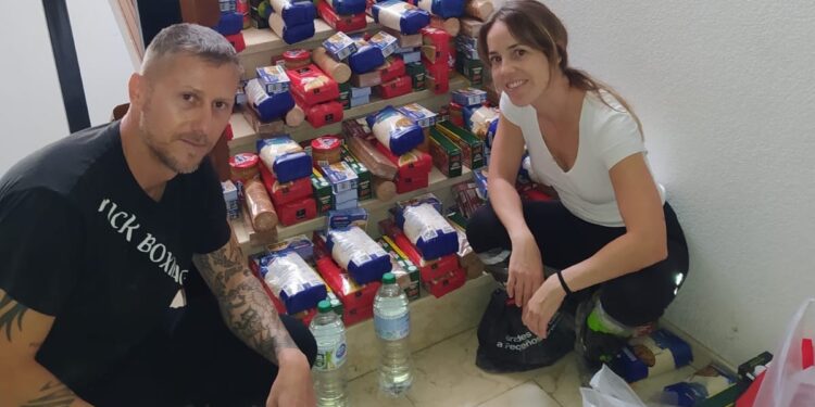 Héctor Hurtado con su pareja, recogiendo alimentos tras sobrevivir a la riada. Foto cedida a Noudiari