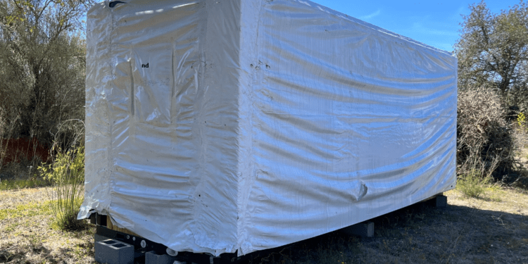Imagen del container casa cubierto con un plástico.