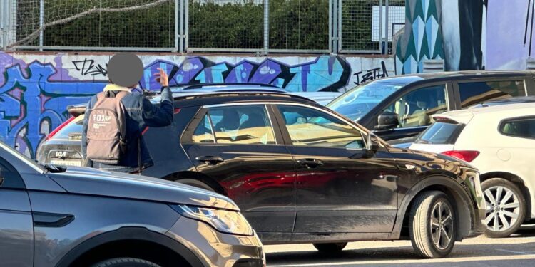 Uno de los 'gorrillas' habituales de la zona haciendo indicaciones de aparcamiento a un conductor ayer miércoles. Fotos Noudiari