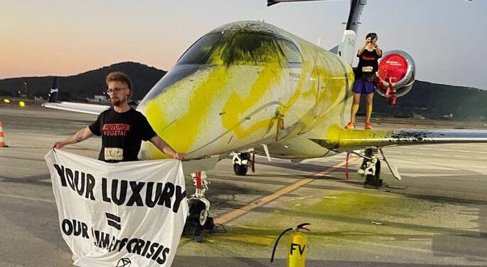 Bilbo Bassaterra, en primer término, sostiene una pancarta tras rociar la pintura. Foto Futuro Vegetal