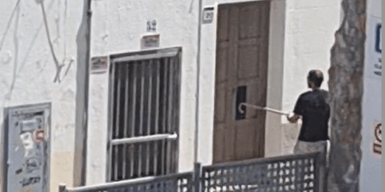 Imagen del individuo intentando entrar en la vivienda con una pata de cabra.