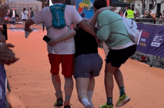 Una de las participantes llegando a la meta con ayuda de otros dos corredores.