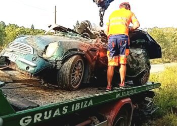 Operarios de Grúas Ibiza retiran el vehículo siniestrado en el que murió una joven.