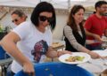 Raquel Guasch Ferrer  y Milena Herrera, repartiendo raciones de paella en Formentera.