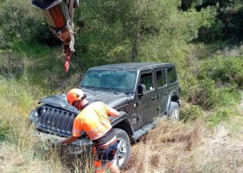 Operarios de Grúas Ibiza retiran el vehículo volcado.