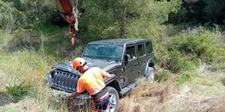 Operarios de Grúas Ibiza retiran el vehículo volcado.