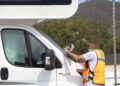 Un agente coloca un aviso de retirada y posible multa a una autocaravana estacionada en Ibiza.