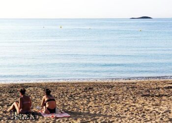 Dos bañistas toman el sol en la playa de ses Figueretes