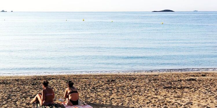 Dos bañistas toman el sol en la playa de ses Figueretes