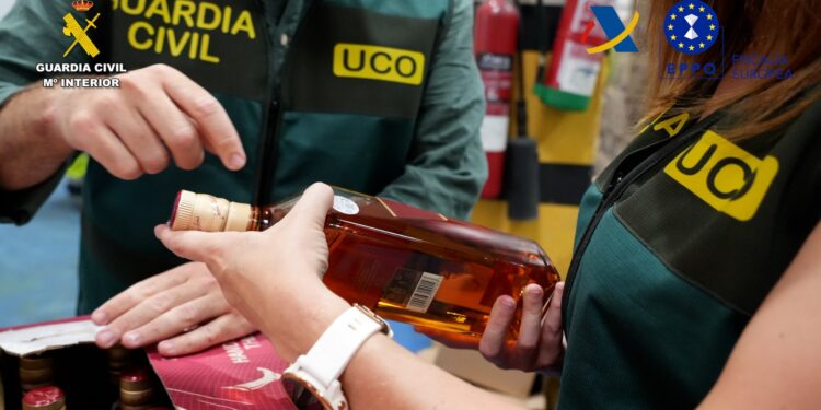 Agentes de la Guardia Civil, con algunas de las botellas confiscadas en el golpe