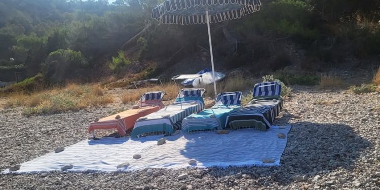 Cada día, desde finales de julio, una furgoneta de una empresa de villas privadas hace este despliegue en la playa. Fotos C. Planells cedidas a Noudiari