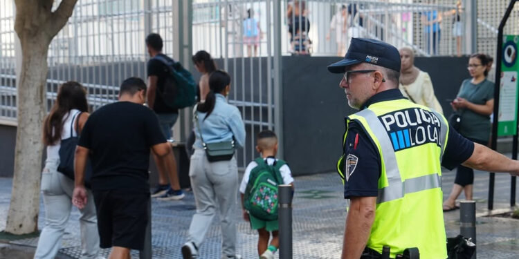 Policía local controla la entrada de alumnos y alumnas en un centro escolar de Ibiza.