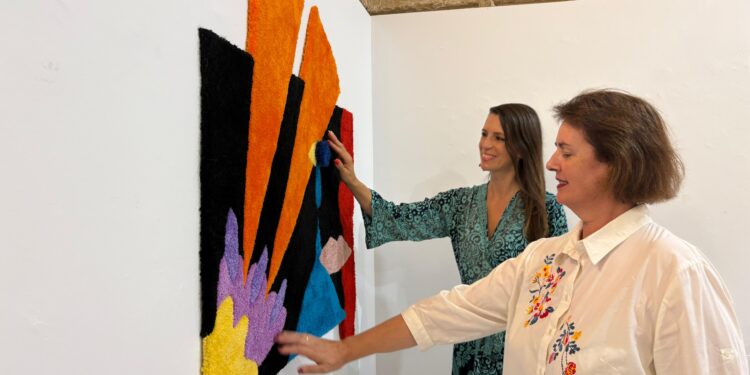 La concejala Carmen Domínguez y la comisaria de la muestra, junto a una de las obras que se expondrán. / AE